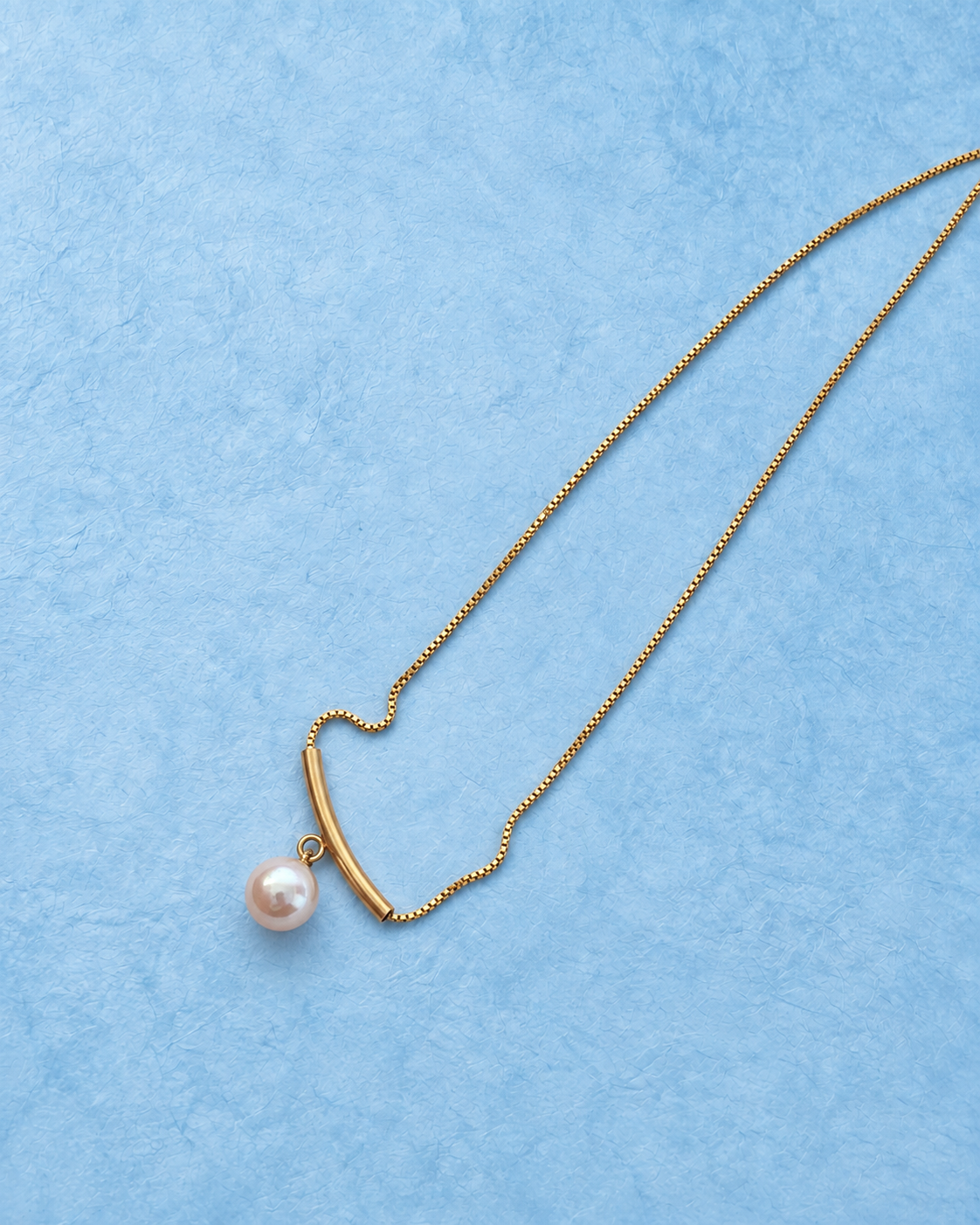 Arcelle Necklace on light blue background