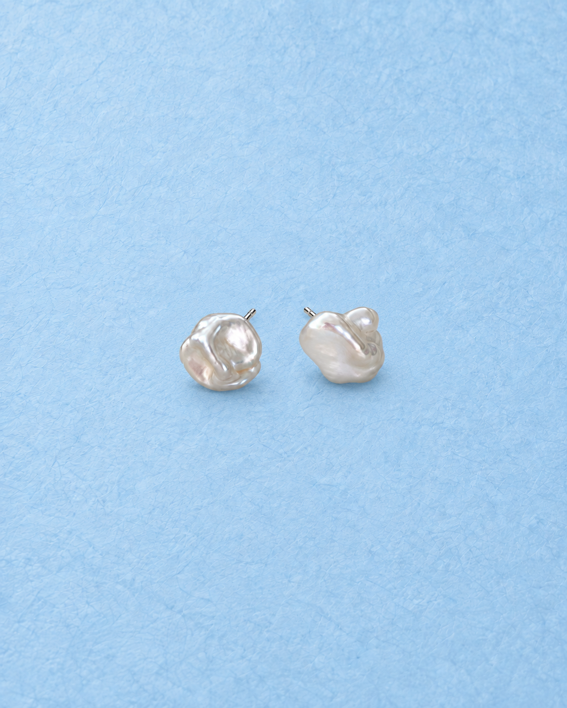 Tessira Earrings on light blue background