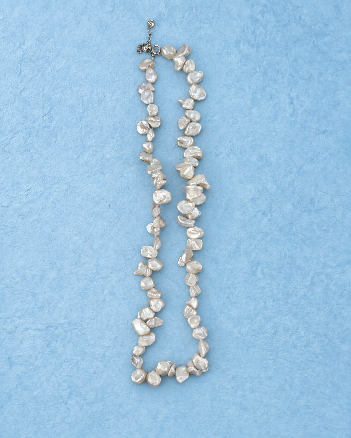 Ivory Nacre Loop Necklace on light blue background