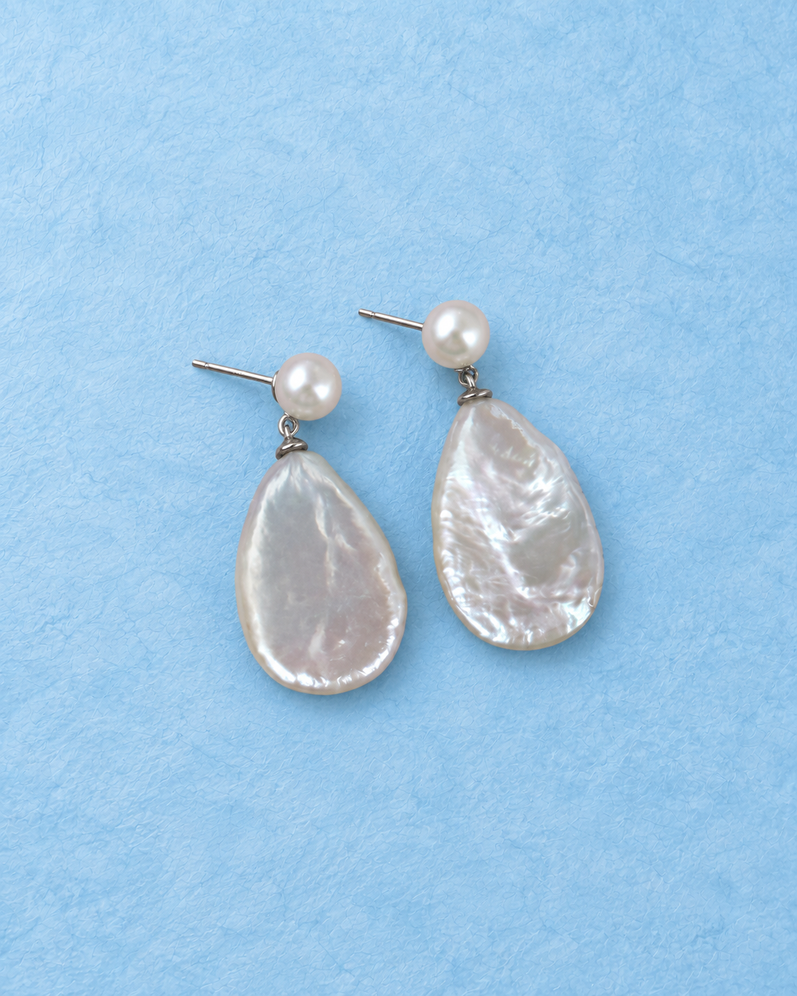 Pluvane Earrings on light blue background