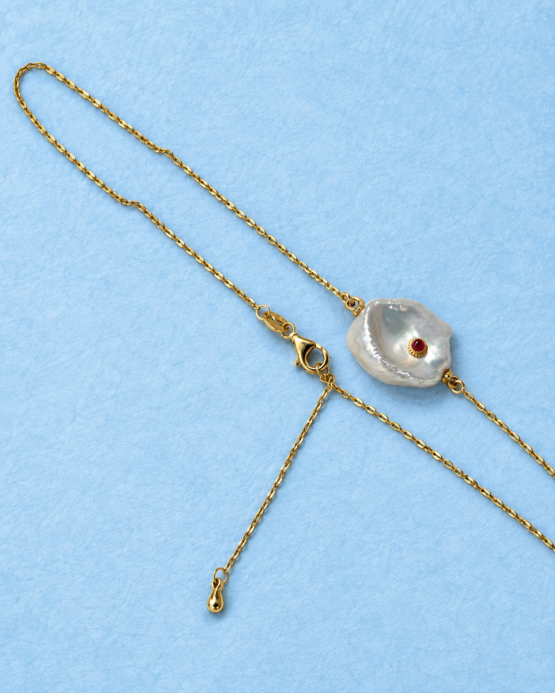 Calyra Necklace on light blue background
