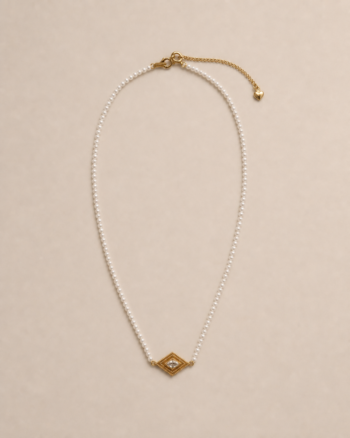 Delphi Pearl Eye Necklace in a warm neutral studio setting