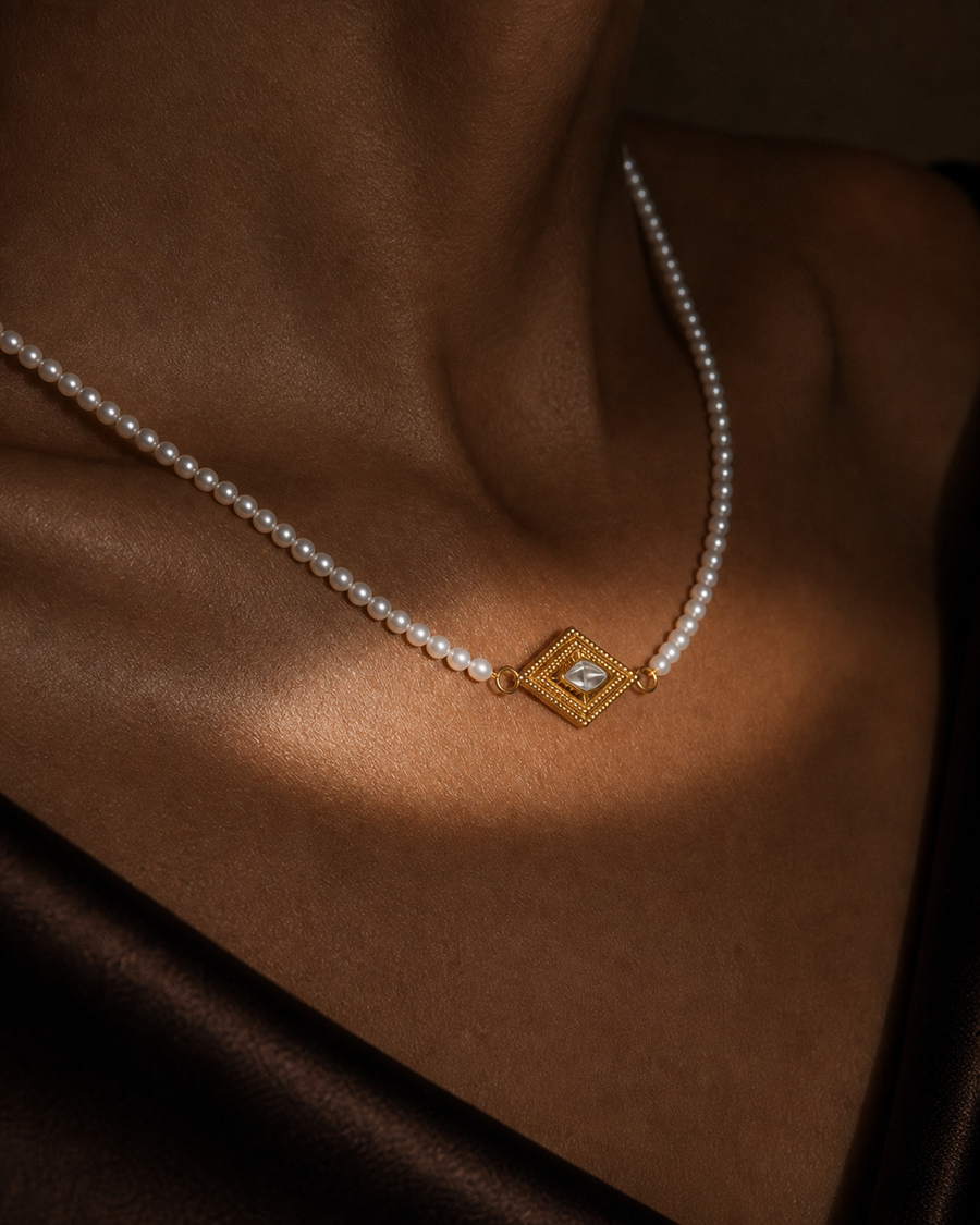 Conceptual close-up of the Delphi Pearl Eye Necklace worn at the collarbone