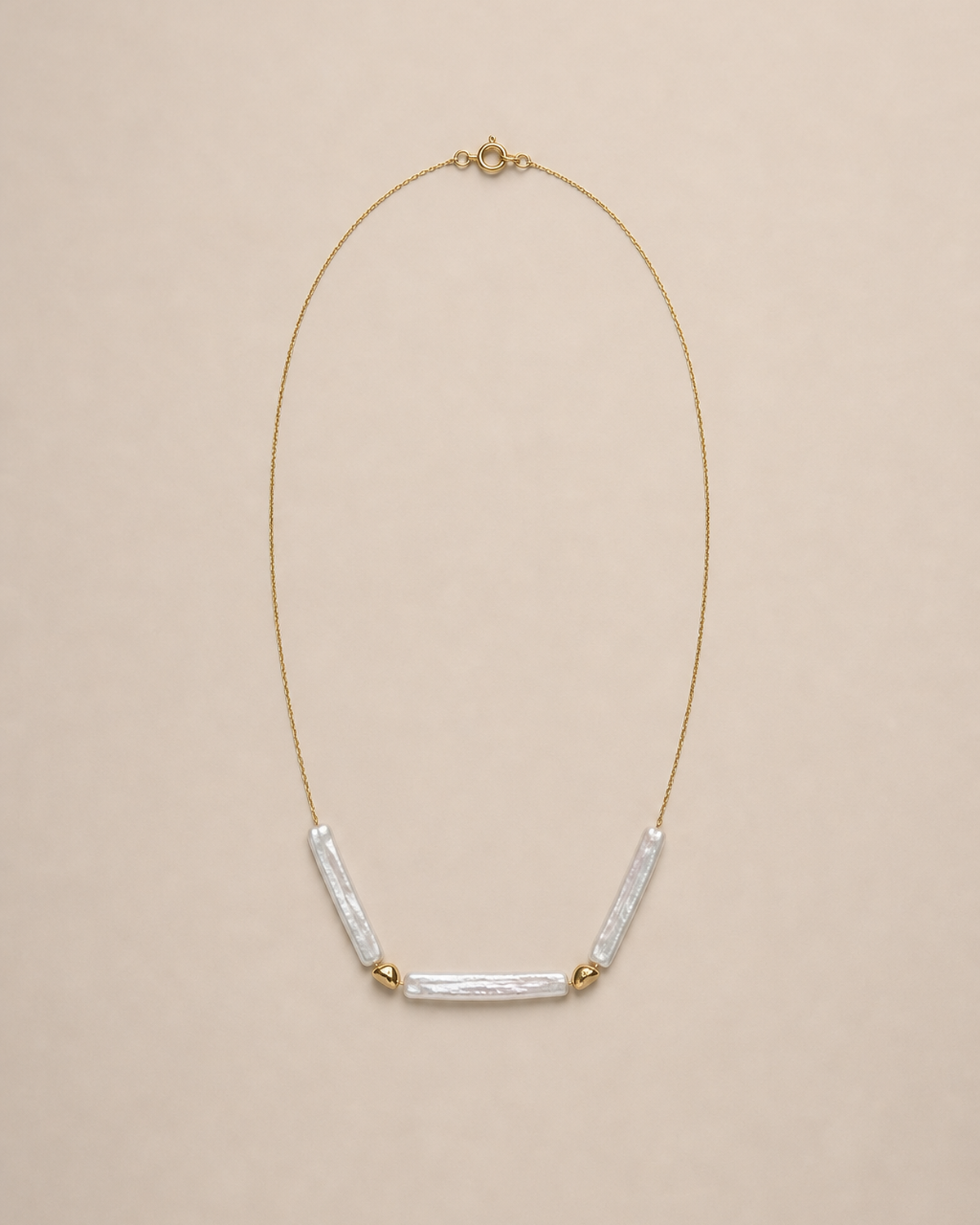Three baroque stick pearl necklace on a warm neutral background