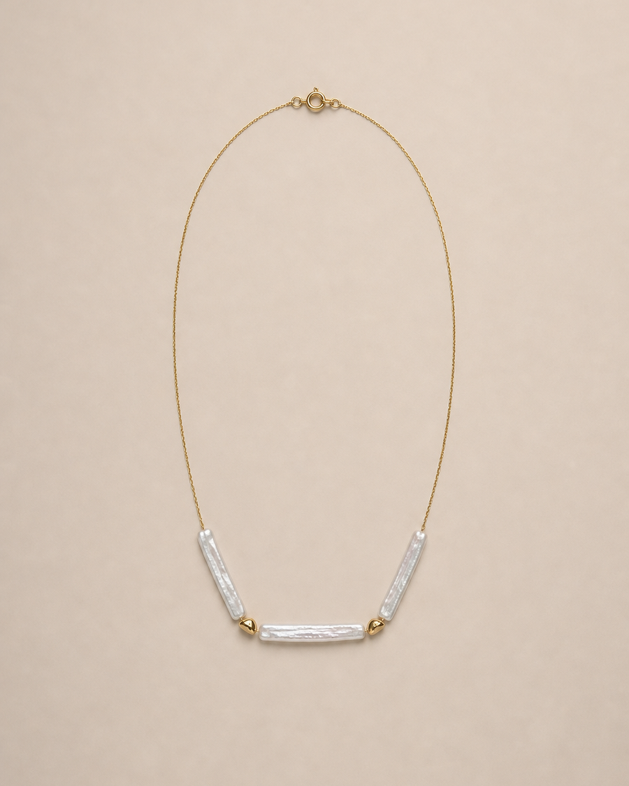 Three baroque stick pearl necklace on a warm neutral background