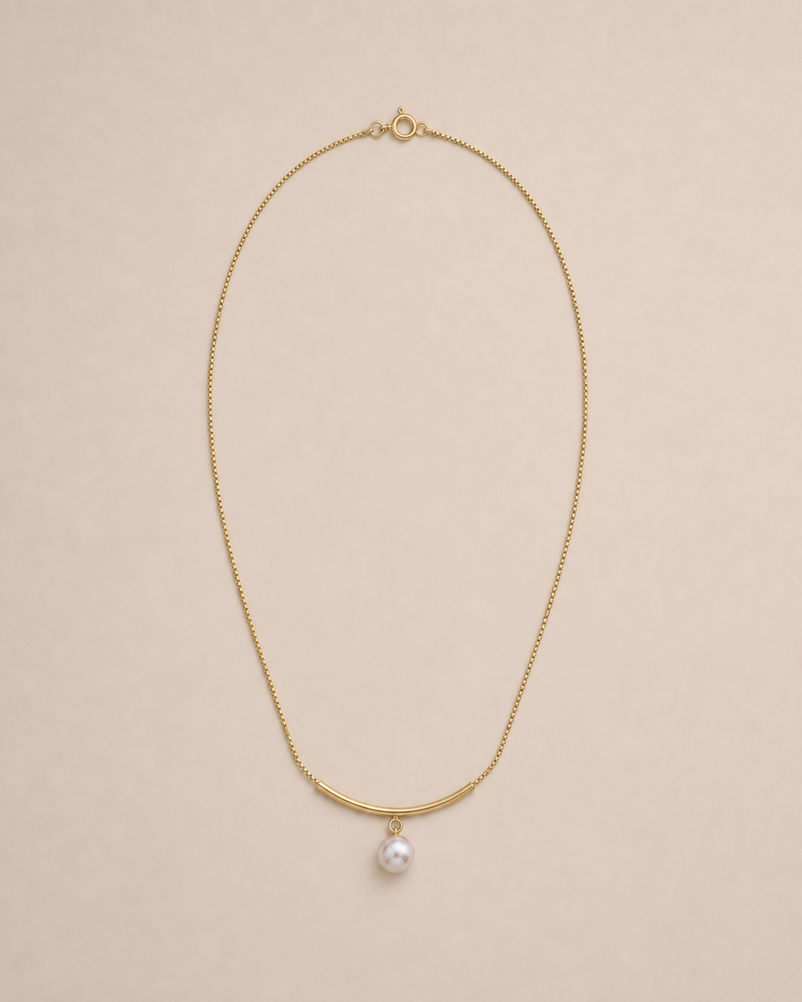 Arc Pearl Drop Necklace on warm greige background