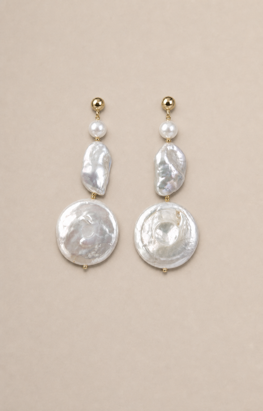 Luna Coin Pearl Drops laid flat with natural contact shadows on warm greige