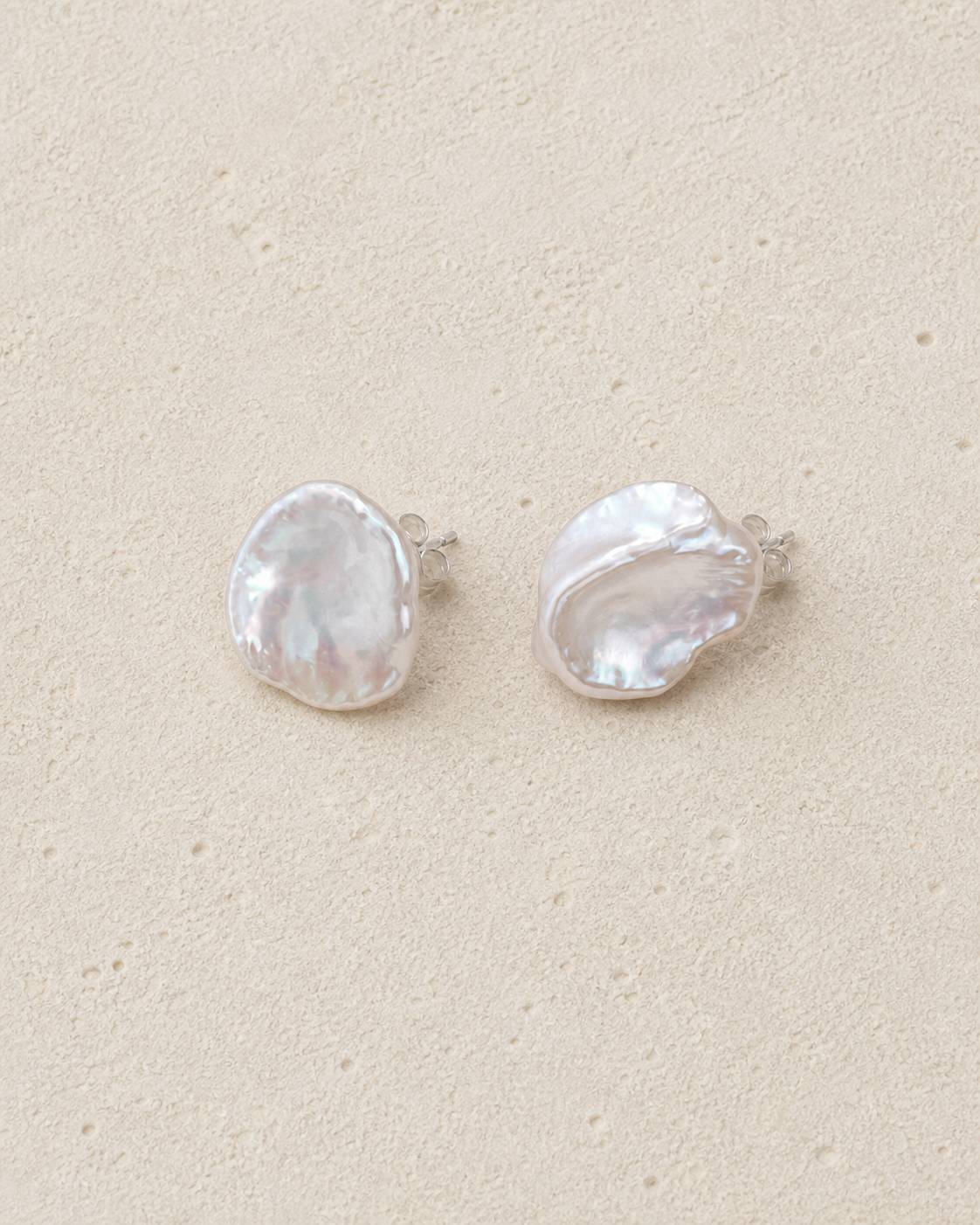 Petal Pearl Studs resting on warm ivory stone