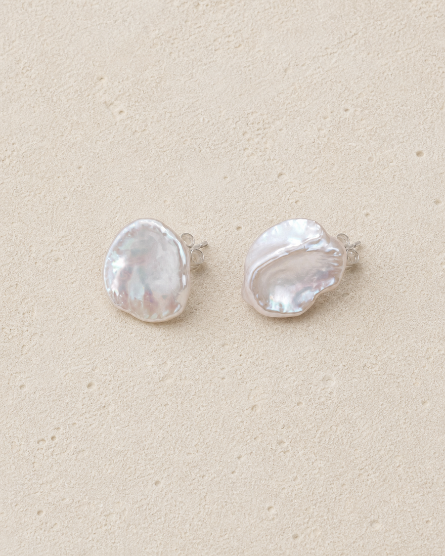 Petal Pearl Studs resting on warm ivory stone