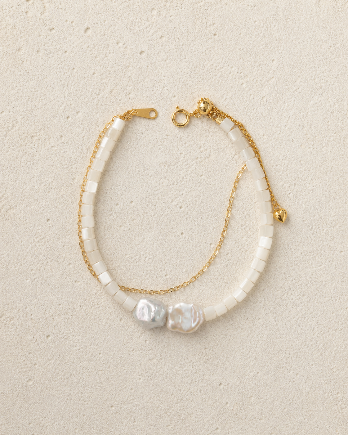Tide Double-Strand Pearl Bracelet resting on warm ivory stone