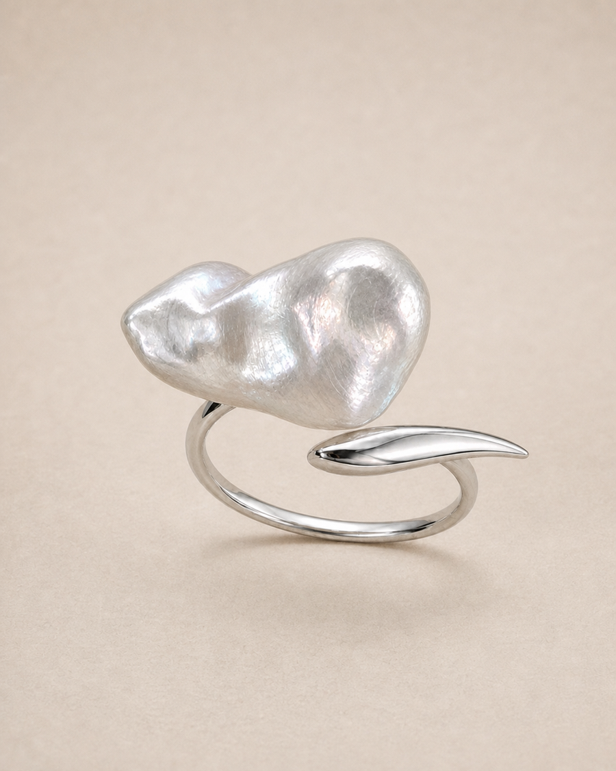 Veil Baroque Pearl Ring with natural baroque pearl texture and polished silver leaf on warm ivory stone