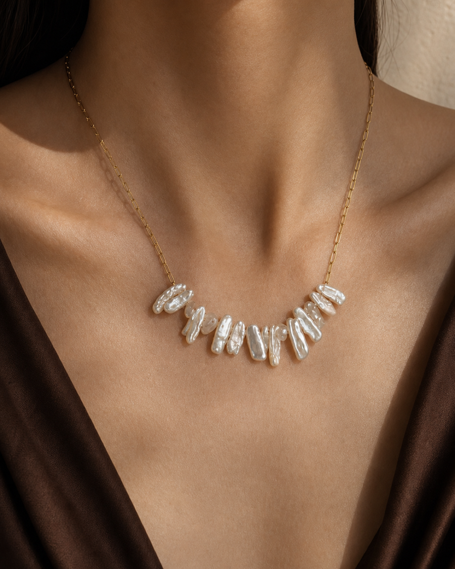 Crescent Biwa Pearl Necklace worn at the collarbone in a faceless warm editorial close-up