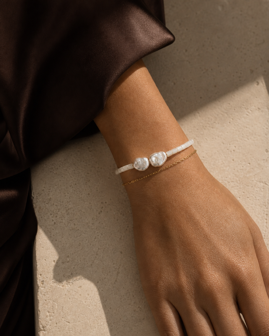 Tide Double-Strand Pearl Bracelet worn on the wrist in a warm bronze and espresso editorial close-up